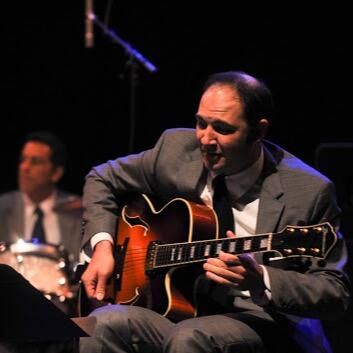 Nate Najar playing a hollow-body guitar on stage
