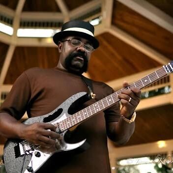 Willie "T Foxx" Thompson playing a silver electric guitar